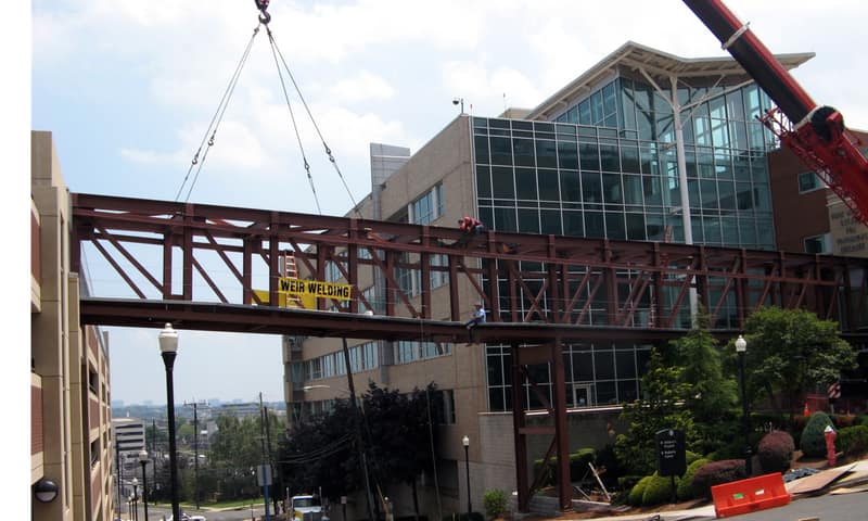 Steel bridge being erected by crane